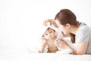 Mother wiping baby with towel