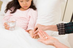 A girl who cared by Grandma is taking pills in bed